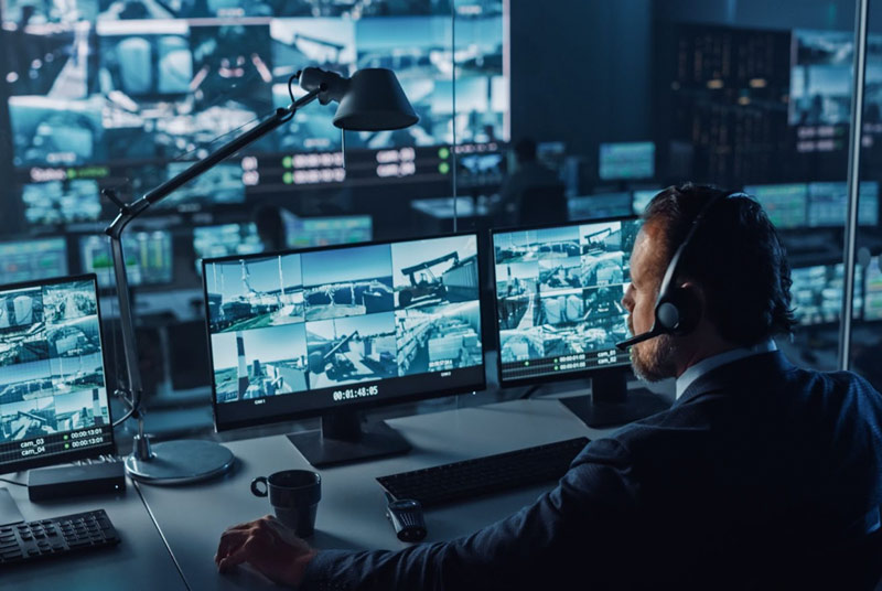 man monitoring security cameras